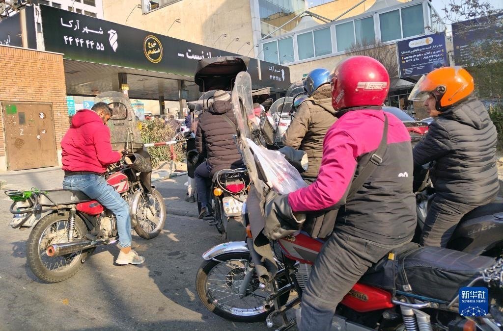 12月18日，摩托車在伊朗首都德黑蘭的一家加油站外等待加油。新華社記者 沙達(dá)提 攝