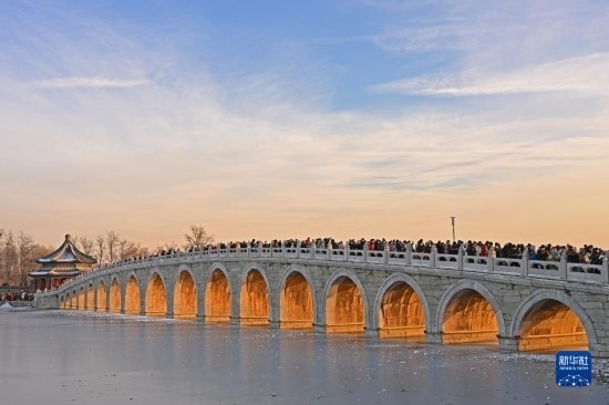 這是12月22日拍攝的頤和園十七孔橋“金光穿洞”景象。