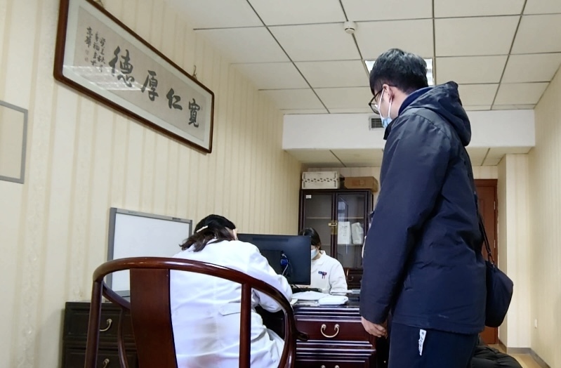 陪診師大飛陪同來(lái)京就診的患者在醫(yī)院?jiǎn)栐\。人民網(wǎng)記者 任妍攝