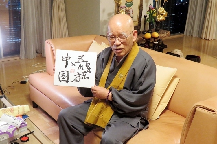 小島康譽(yù)展示自己書(shū)寫(xiě)的“五星出東方利中國(guó)”。視頻截圖