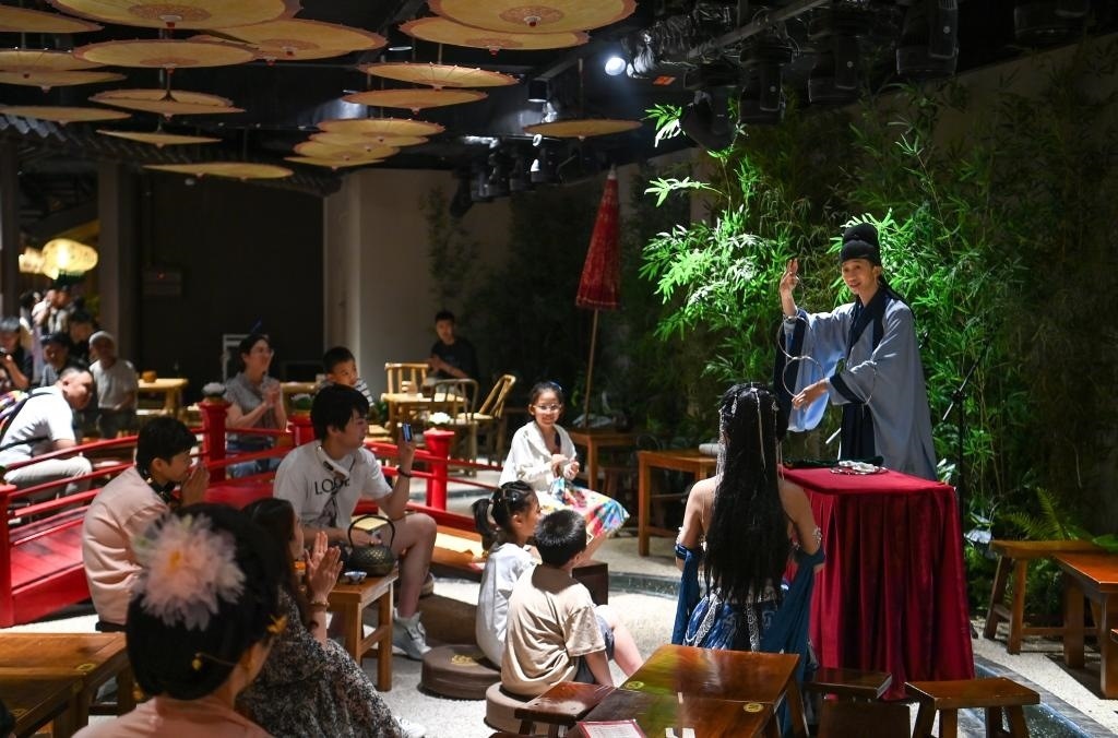 游客在長安十二時辰主題街區(qū)觀看唐風(fēng)演藝《大唐曲藝》。新華社記者鄒競一 攝