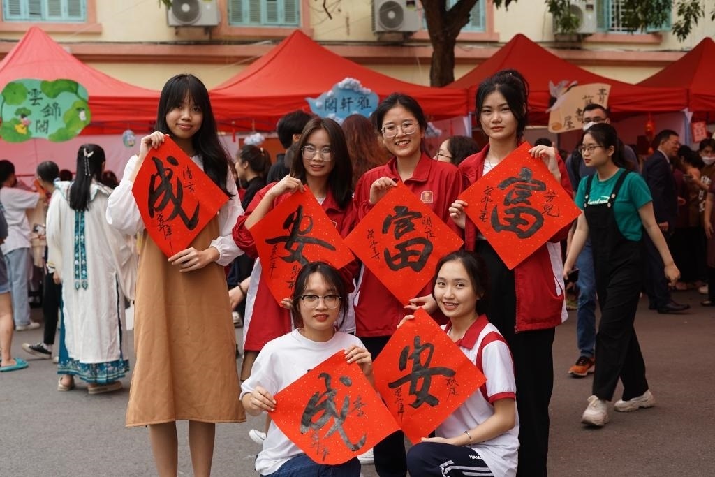 2023年4月21日，在越南河內(nèi)大學(xué)孔子學(xué)院，越南大學(xué)生展示漢字書法作品。新華社記者胡佳麗攝