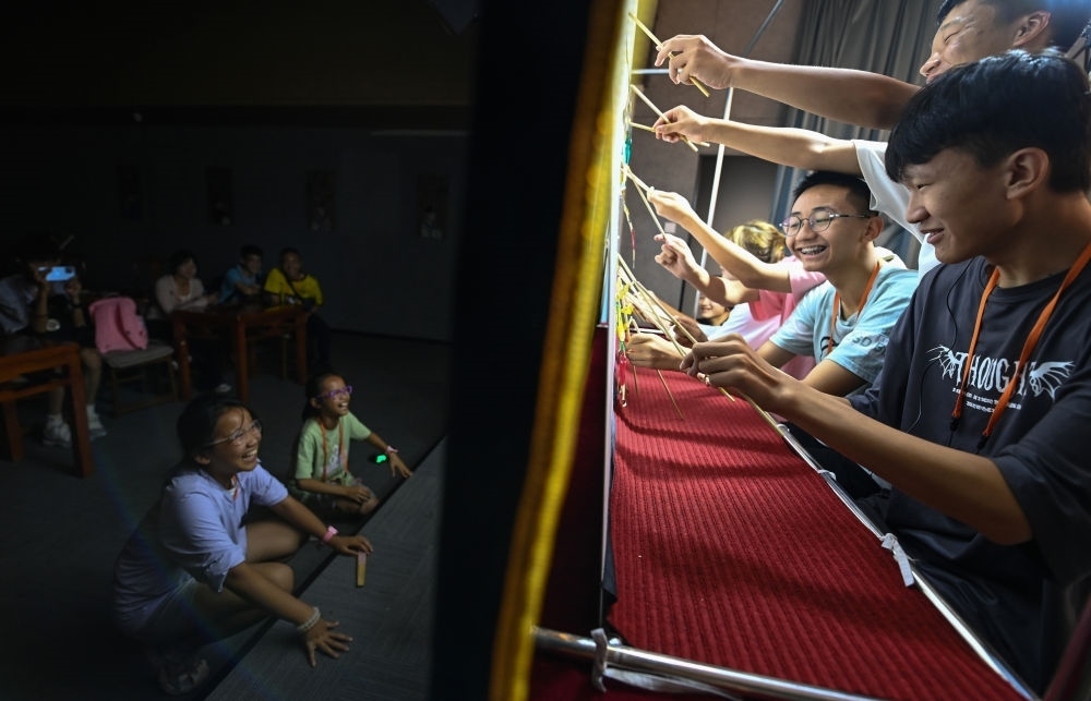 2023年8月8日，進(jìn)行暑期研學(xué)的學(xué)生在位于陜西省西安市的中國(guó)秦腔藝術(shù)博物館體驗(yàn)皮影戲演出。新華社記者 鄒競(jìng)一 攝