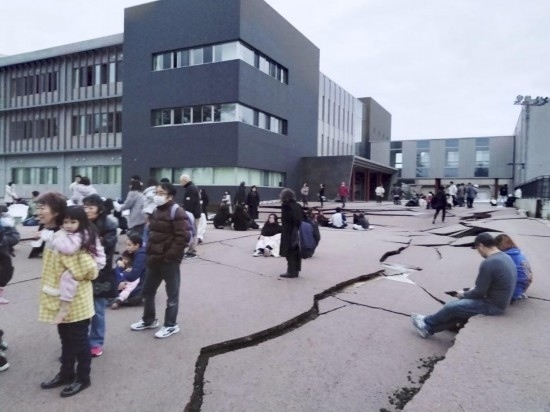  1月1日，在日本石川縣輪島市，人們站在被地震破壞的地面上。新華社/共同社