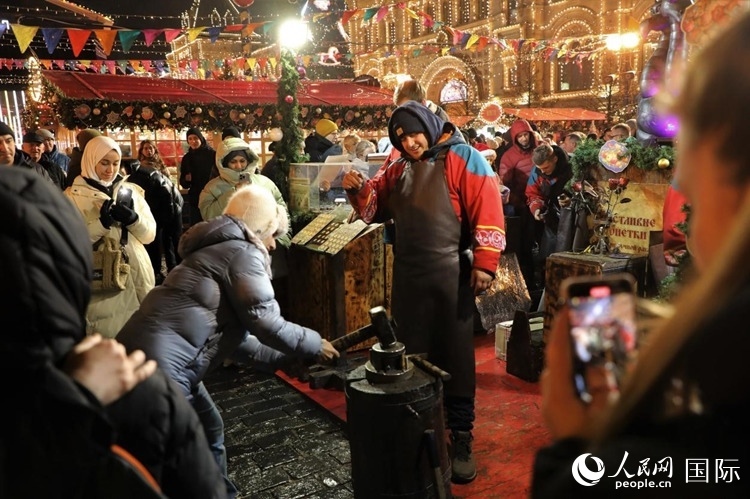 游客在新年集市上體驗(yàn)制作紀(jì)念幣。人民網(wǎng)記者 隋鑫攝