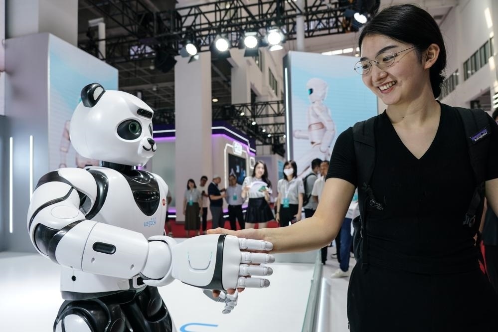 2023年8月16日，一名女士在北京舉辦的2023世界機(jī)器人大會(huì)現(xiàn)場(chǎng)與智能機(jī)器人握手。新華社記者彭子洋攝
