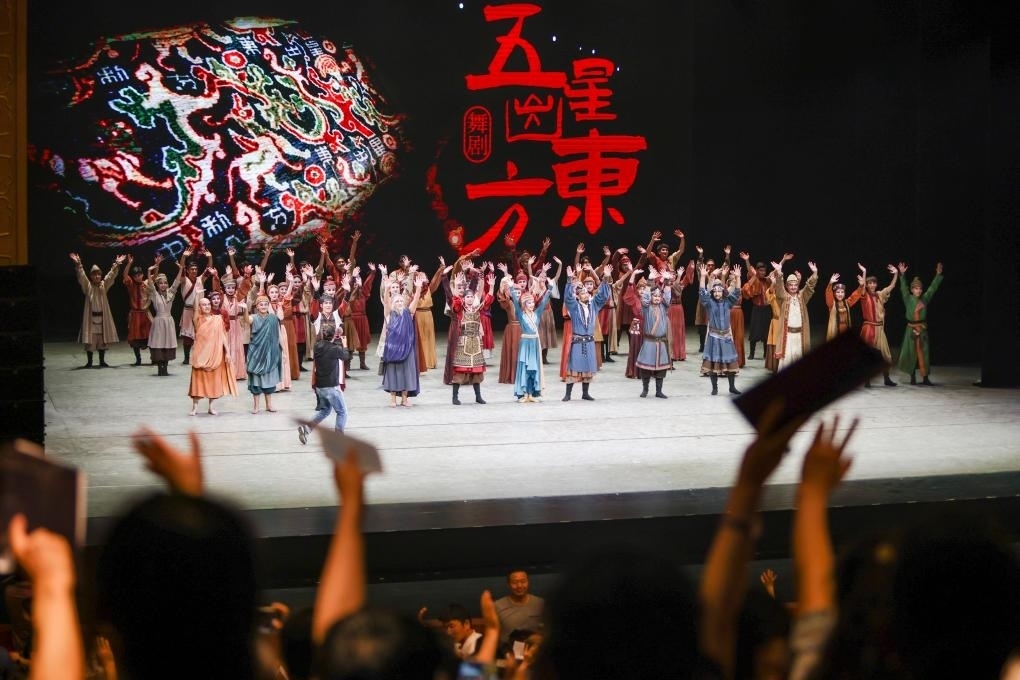 2023年7月31日，新疆和田地區(qū)新玉歌舞團在烏魯木齊京劇院演出舞劇《五星出東方》后和觀眾互相揮手致意。這場演出是第六屆中國新疆國際民族舞蹈節(jié)的參演劇目之一，曾榮獲國家“文華獎”等。新華社記者 郝昭 攝