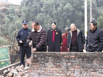  圖③：庭審結(jié)束后，在法官的見(jiàn)證下，陳某在院壩邊重新開(kāi)鑿一條通道。