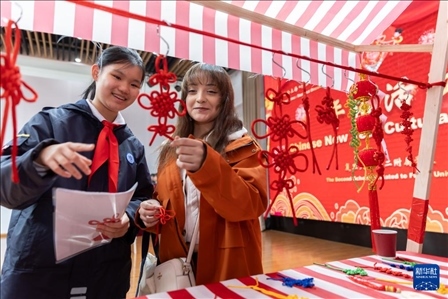 1月28日，復(fù)旦大學(xué)第二附屬學(xué)校學(xué)生（左）為美國馬斯卡廷中學(xué)學(xué)生（右）介紹中國結(jié)。 新華社記者 王翔 攝