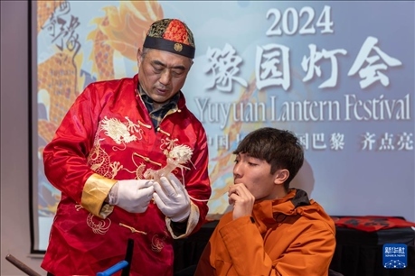 1月28日，在上海豫園舉行的民俗活動上，美國馬斯卡廷中學(xué)學(xué)生在非遺傳承人的指導(dǎo)下吹糖偶。 新華社記者 王翔 攝