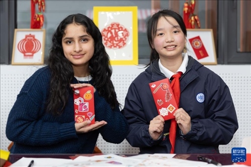 1月28日，美國馬斯卡廷中學(xué)學(xué)生（左）和復(fù)旦大學(xué)第二附屬學(xué)校學(xué)生展示互相送出的寫有寄語祝福的紅包。 新華社記者 王翔 攝