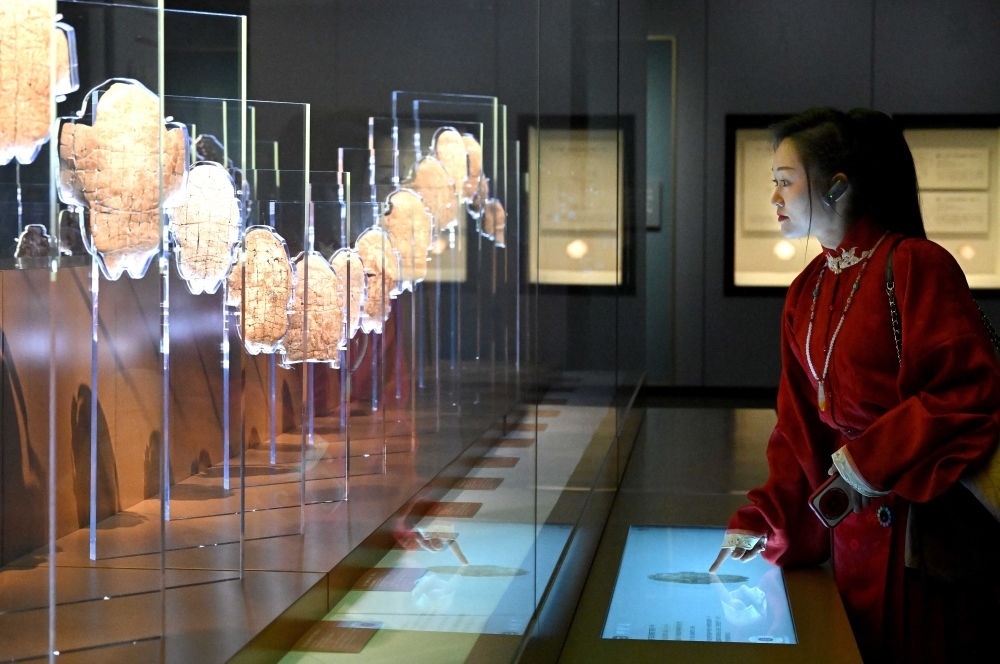 2月26日，參觀者在河南安陽殷墟博物館新館內(nèi)觀看展出的刻辭卜甲。
