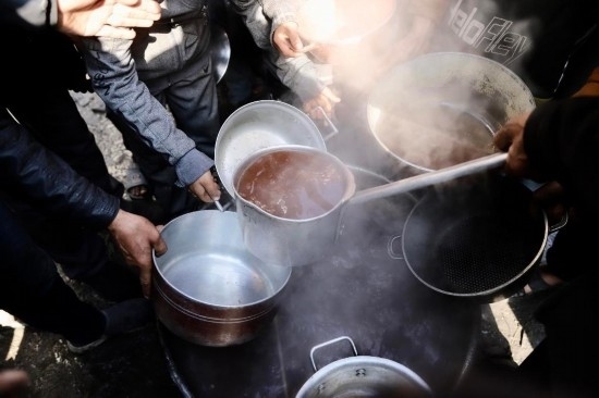  2月27日，在加沙地帶北部的杰巴利耶難民營(yíng)，人們領(lǐng)取食物。新華社發(fā)（穆罕默德·阿里攝）