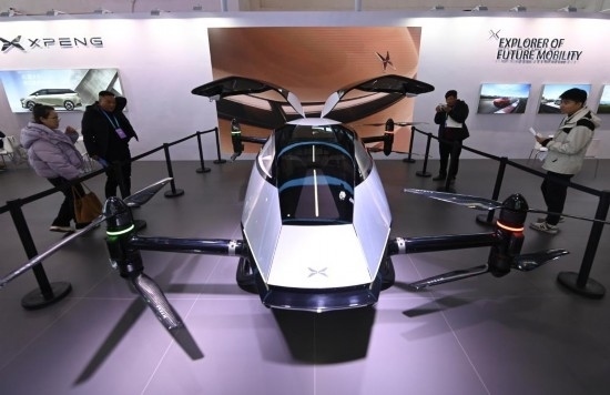 2023年12月1日，在鏈博會智能汽車鏈展區(qū)小鵬汽車展臺，參觀者觀看一臺智能飛行器。新華社記者蔡湘鑫攝