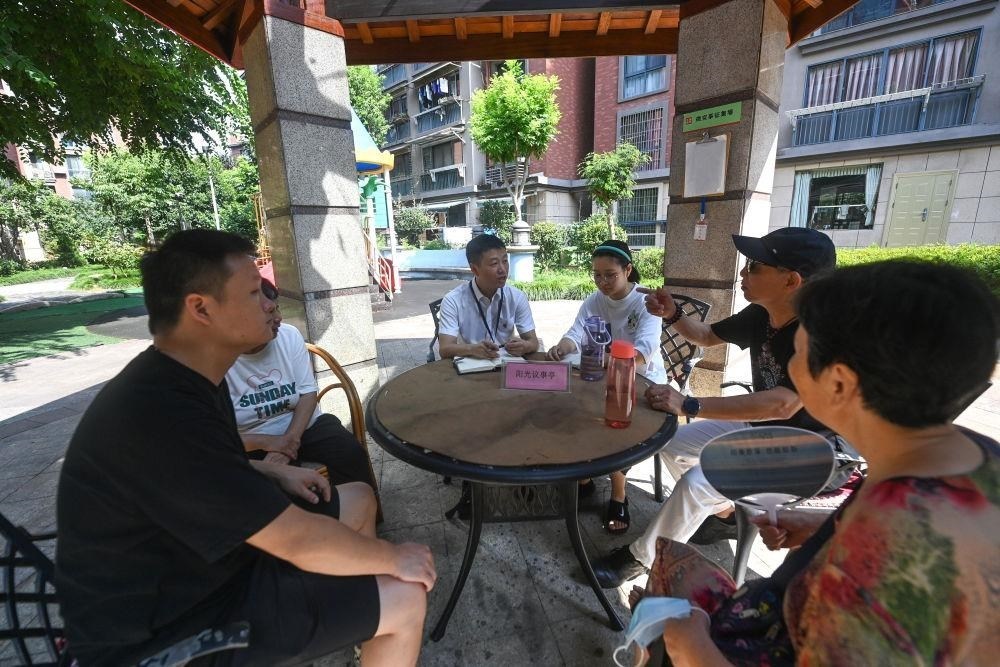 △2023年7月21日，在位于浙江杭州臨安區(qū)錦南街道水岸陽光小區(qū)的陽光議事廳，街道干部在聽取居民們反映的問題及意見。