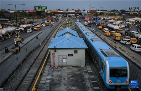 3月4日，在尼日利亞拉各斯，一列輕軌藍(lán)線列車行駛至公路交通擁堵路段附近。新華社記者 韓旭 攝