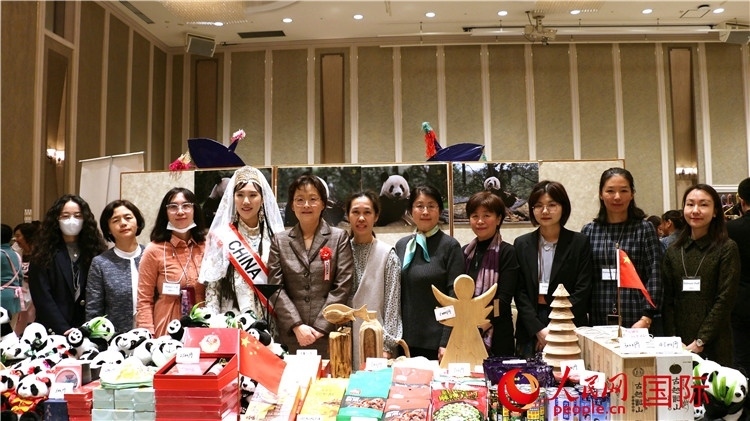 中國駐日本大使吳江浩夫人丁玥（左五）與使館人員在展位前合影留念。人民網(wǎng) 許可攝