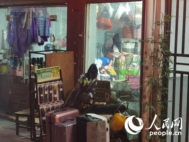 南寧“城中村”一裁縫鋪老板將電線從店內(nèi)拉出為電動(dòng)自行車充電。人民網(wǎng) 覃心攝