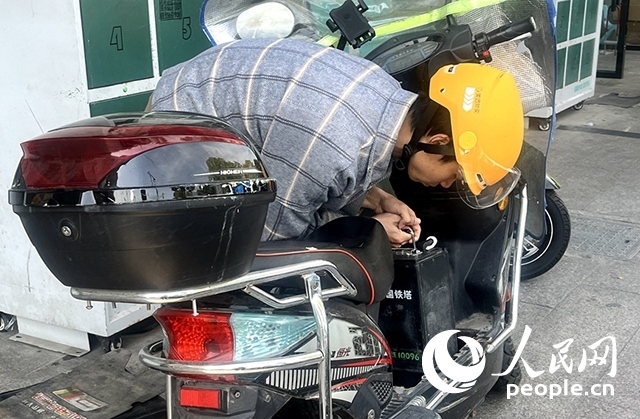 杭州一名外賣騎手正在更換共享電池。人民網(wǎng)記者 張麗瑋攝