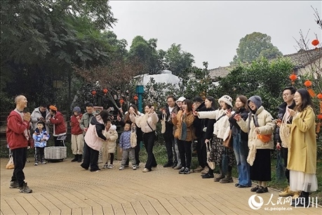 葉科（左一）給前來參與活動(dòng)的“柑爸柑媽”介紹生態(tài)種植果。人民網(wǎng)記者朱虹攝