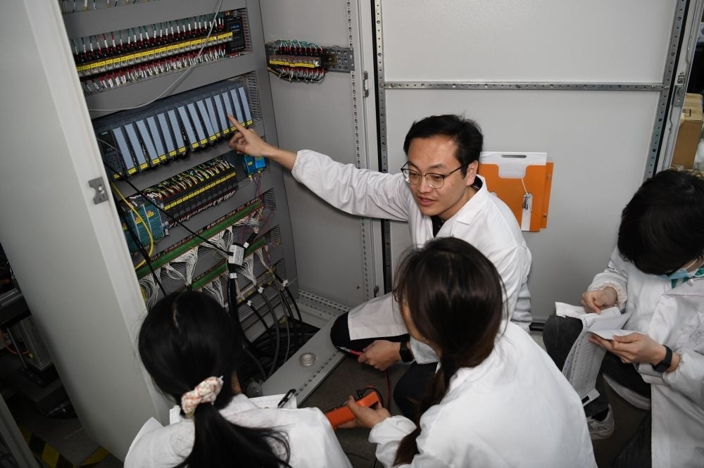 2024年4月6日，在位于安徽合肥的中國科學(xué)技術(shù)大學(xué)，安徽省先進功能高分子薄膜工程實驗室團隊成員在檢修自主研制的高分子薄膜原位雙向拉伸實驗設(shè)備的電氣控制系統(tǒng)。