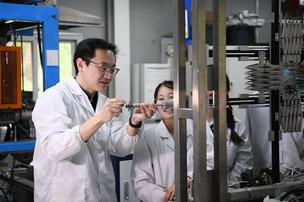 2024年4月6日，在位于安徽合肥的中國科學(xué)技術(shù)大學(xué)，安徽省先進功能高分子薄膜工程實驗室團隊成員朱健和（左）在和同事討論實驗設(shè)備的設(shè)計方案。