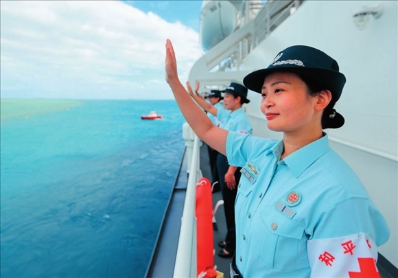 中國海軍“和平方舟”號醫(yī)院船結(jié)束訪問湯加時，任務官兵中的文職人員向歡送人群揮手告別（2023年8月4日攝）。徐巍攝/本刊
