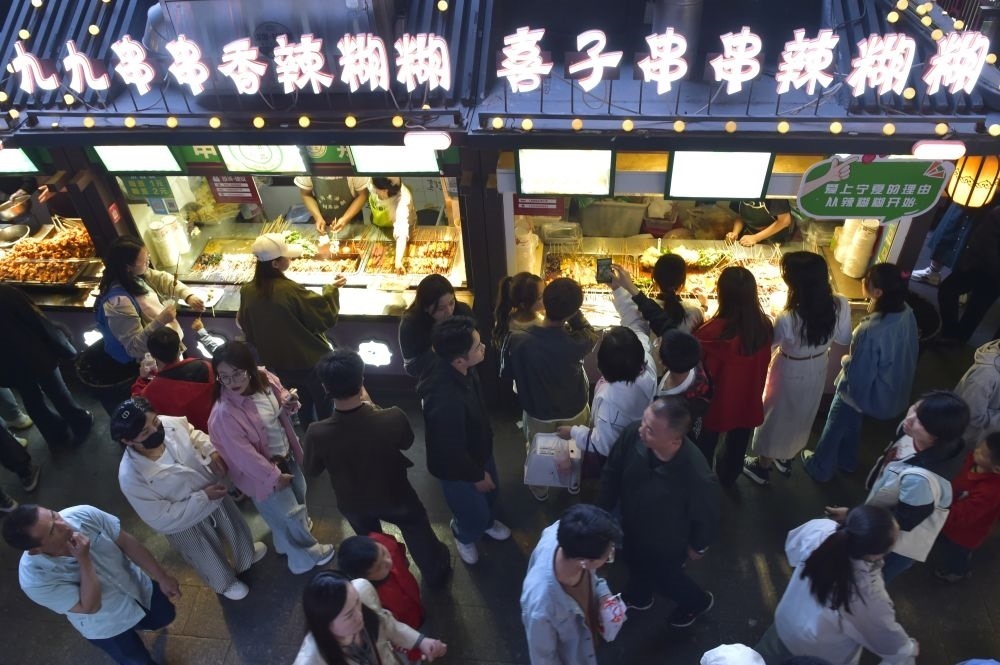 2024年5月4日，游客在寧夏銀川懷遠(yuǎn)夜市品嘗當(dāng)?shù)鼐W(wǎng)紅美食辣糊糊。新華社記者 毛竹 攝