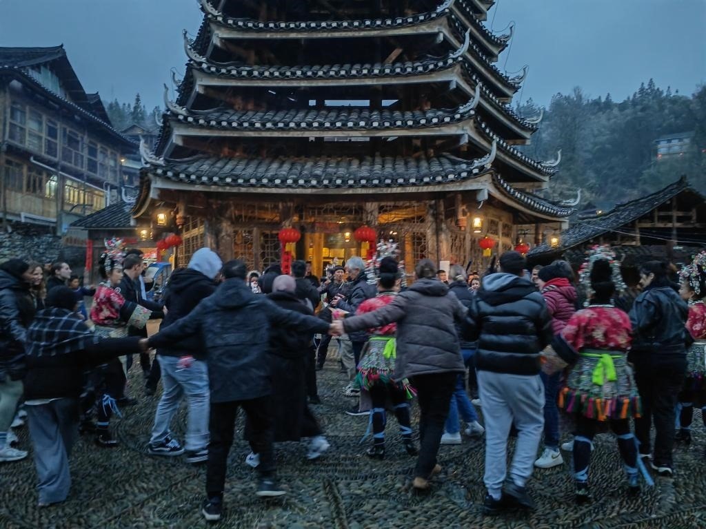 法國青年與當(dāng)?shù)卮迕駹渴痔?。新華社記者 羅羽 攝