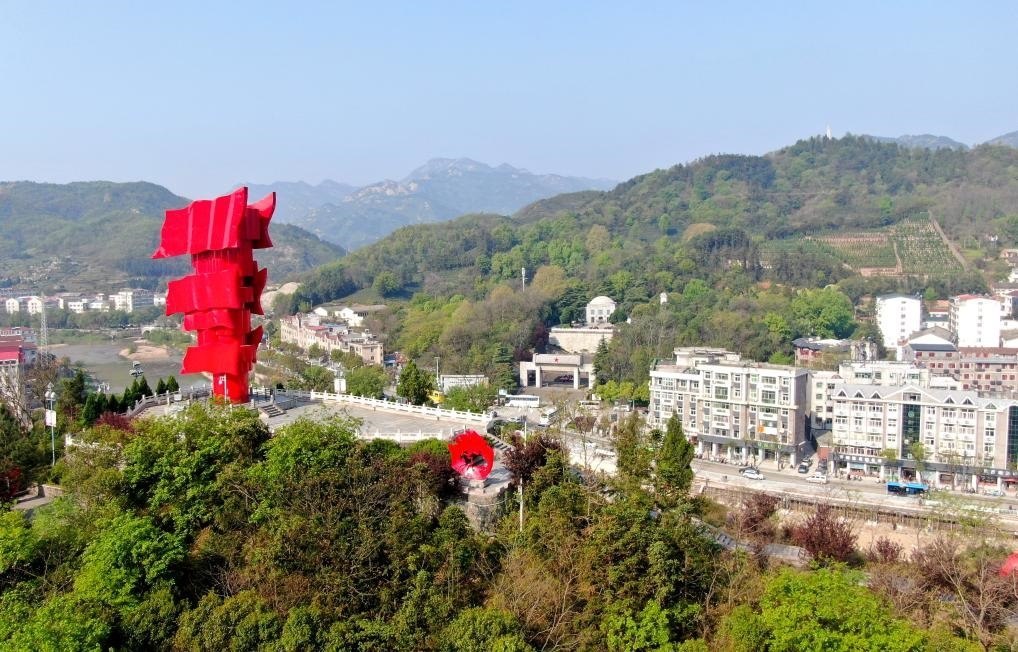 這是2021年4月9日拍攝的鄂豫皖蘇區(qū)首府革命博物館附近的英雄山上的“紅旗飄飄”主題雕塑（無人機照片）。新華社發(fā)