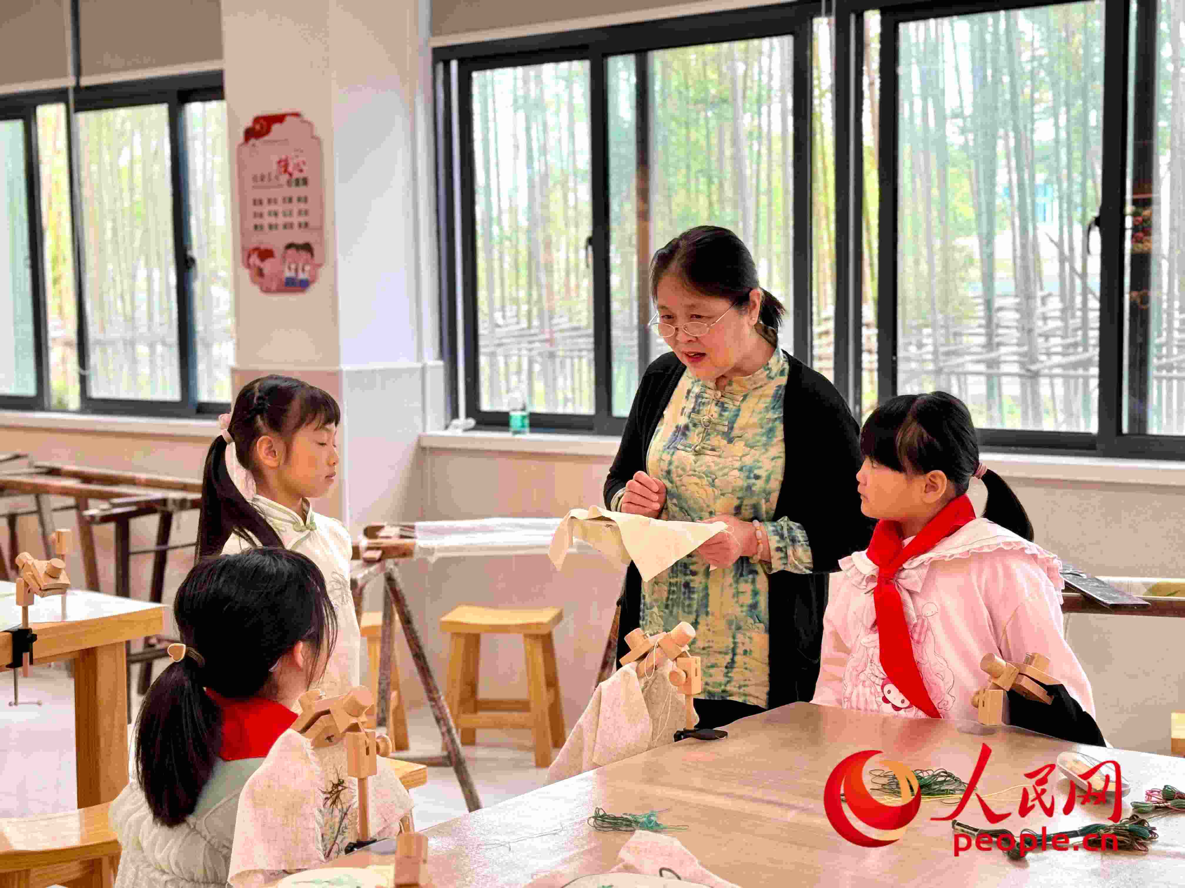 顧建珍（左三）在教孩子們刺繡知識(shí)。人民網(wǎng) 周靜圓攝