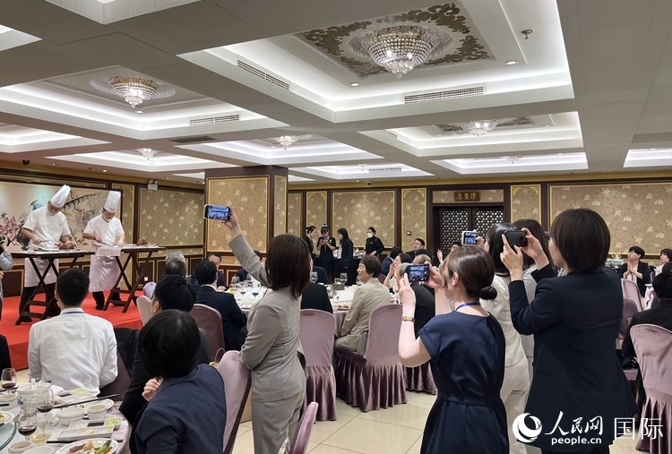 國家級非物質(zhì)文化遺產(chǎn)、全聚德片鴨工藝吸引代表團成員拍照留念。