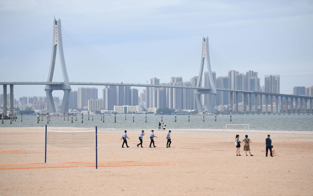 2023年7月17日，廣東湛江五環(huán)廣場的沙灘上，公安民警在執(zhí)勤巡邏。新華社記者 鄧華 攝