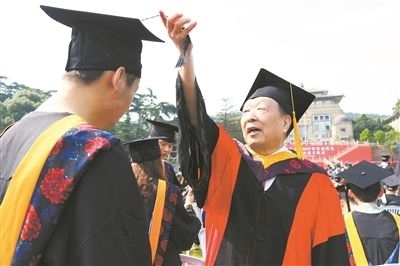 2017年6月22日，李德仁（右一）參加武漢大學(xué)畢業(yè)典禮并為畢業(yè)生撥穗。