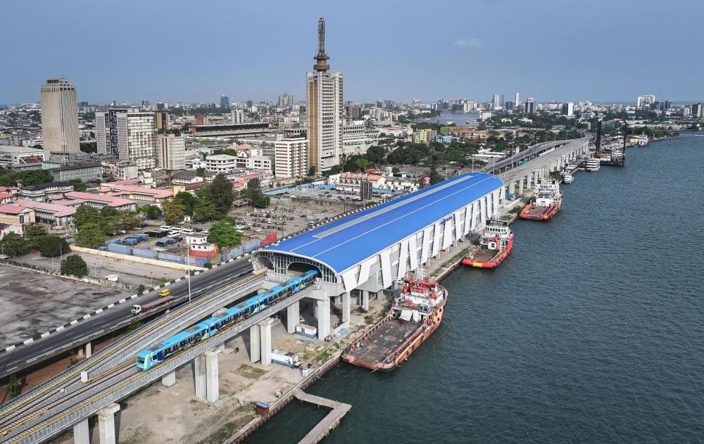 2024年3月2日，在尼日利亞拉各斯，一列輕軌藍(lán)線列車駛?cè)氪a頭站（無人機照片）。拉各斯輕軌藍(lán)線是西非地區(qū)首條由中國企業(yè)自主設(shè)計、建造、施工、運營的電氣化城市軌道交通項目。新華社記者 韓旭 攝