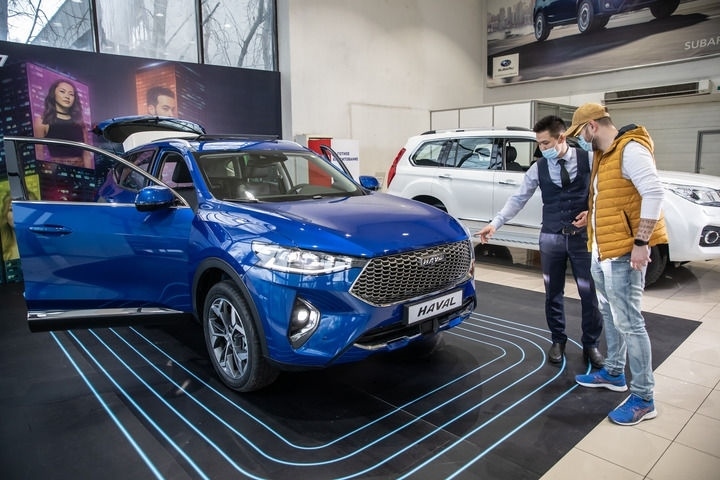 2021年4月1日，銷售人員在哈薩克斯坦阿拉木圖市經(jīng)銷商店向消費(fèi)者介紹哈弗汽車。新華社發(fā)（阿斯塔納汽車公司供圖）