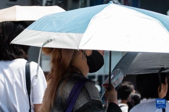 7月4日，人們?cè)谌毡緰|京原宿的街道上等待紅綠燈。新華社記者 張笑宇 攝