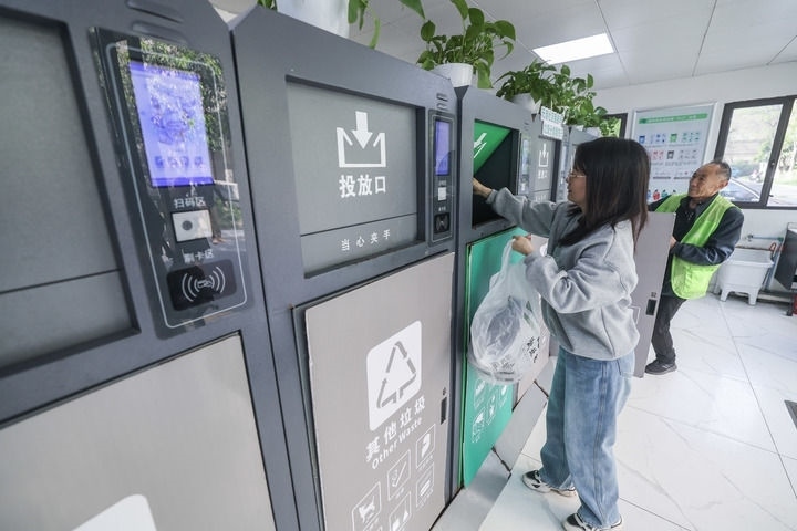 2024年4月10日，在浙江省湖州市吳興區(qū)飛英街道新華府小區(qū)內(nèi)，居民在垃圾分類智能系統(tǒng)的指導(dǎo)下進(jìn)行垃圾分類投放，居民的投放情況將實(shí)時(shí)匯總到智慧服務(wù)平臺(tái)，會(huì)有相應(yīng)的積分獎(jiǎng)勵(lì)。新華社記者 徐昱 攝
