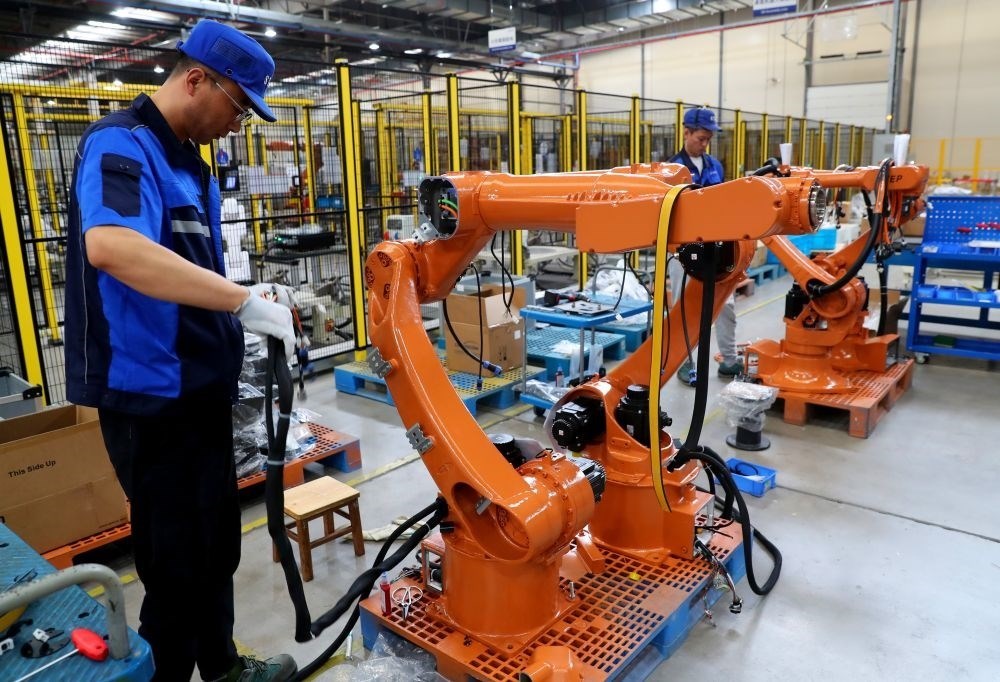 工作人員在上海新時(shí)達(dá)機(jī)器人有限公司位于嘉定的智能工廠內(nèi)忙碌（2024年5月23日攝）。新華社記者 龔兵 攝