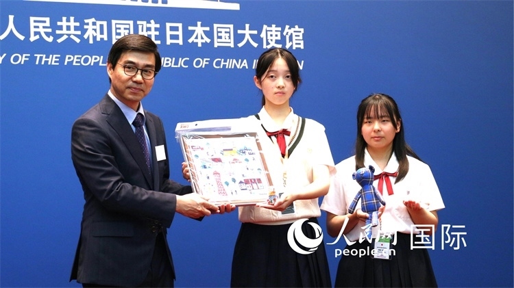 日本小大使向中國駐日本大使館臨時(shí)代辦施泳贈(zèng)送當(dāng)?shù)靥厣Y品。人民網(wǎng) 許可攝