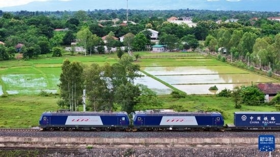 8月5日，由老撾籍火車司機(jī)獨(dú)立駕駛的滿載貨物的列車駛出萬象站，向中國昆明進(jìn)發(fā)（無人機(jī)照片）。新華社發(fā)（楊永全 攝）
