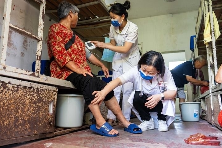 2024年7月30日，在湖南省湘潭縣河口中學安置點，醫(yī)務(wù)人員為受洪水影響而轉(zhuǎn)移安置的群眾檢查身體。 新華社記者 陳思汗 攝