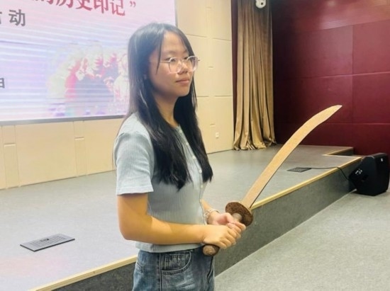 圖為南開大學(xué)社會(huì)實(shí)踐隊(duì)學(xué)生代表呼月紅在學(xué)術(shù)交流活動(dòng)現(xiàn)場(chǎng)，展示河間調(diào)研行中獲贈(zèng)的一戰(zhàn)華工蔡世春曾使用過的一把大刀。林卓瑋 攝