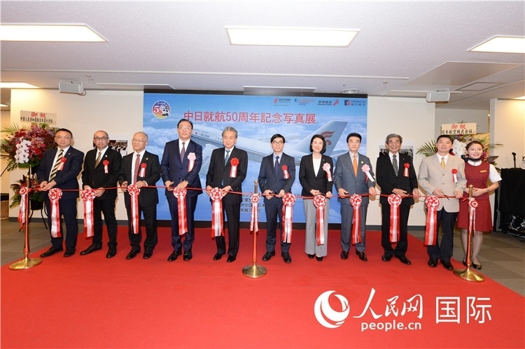 與會(huì)嘉賓共同為中日通航50周年紀(jì)念圖片展開(kāi)幕剪彩。馮學(xué)敏攝