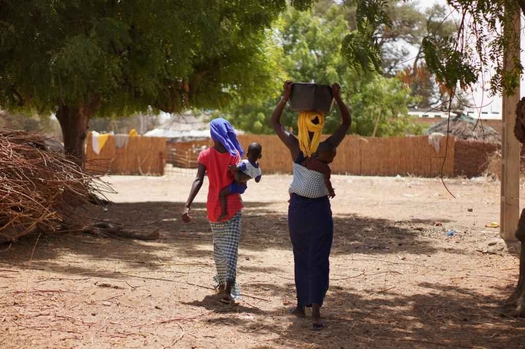 2023年3月20日，在塞內(nèi)加爾久爾貝勒區(qū)的泰內(nèi)富勒村，村民將取到的水運(yùn)回家。新華社記者 王子正 攝