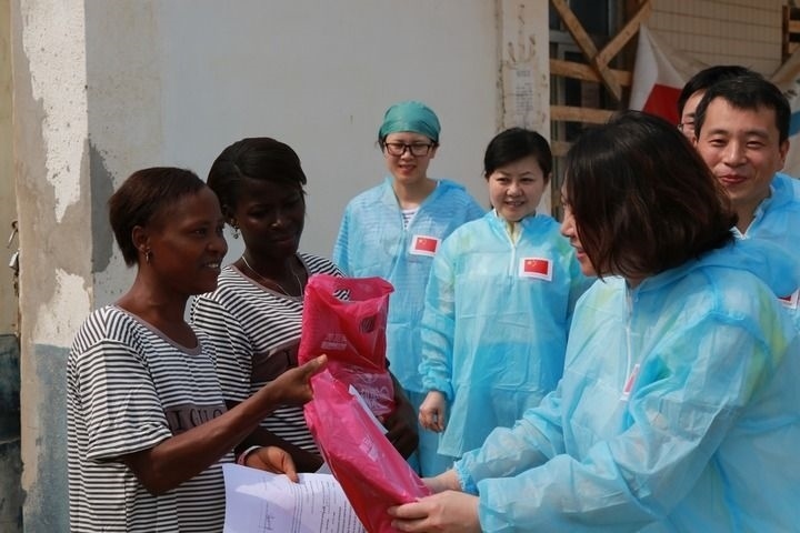 2015年4月4日，在位于塞拉利昂首都弗里敦市郊的中塞友好醫(yī)院埃博拉診療中心，中國第四批援塞醫(yī)療隊(duì)副隊(duì)長邵蔚（右前）向被治愈的埃博拉出血熱患者贈(zèng)送禮物。新華社發(fā)（祖榮強(qiáng) 攝）