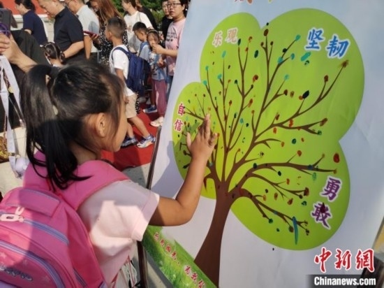 圖為衡水市利民路小學(xué)，孩子們?cè)诔砷L(zhǎng)樹的“好習(xí)慣”樹枝上按手印做出承諾。張松 攝