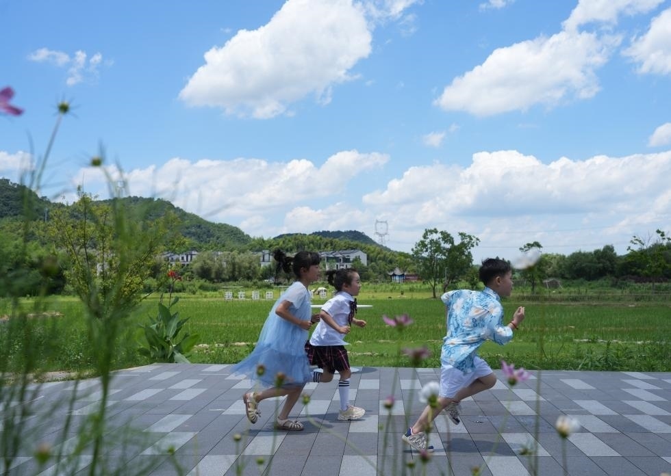 兒童在余姚市梁弄鎮(zhèn)的田野間奔跑（7月3日攝）。新華社記者翁忻旸 攝