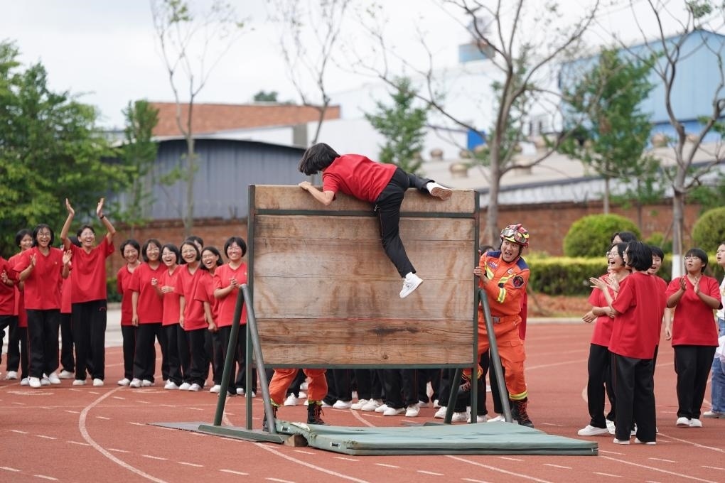 云南麗江華坪女子高級(jí)中學(xué)學(xué)生在體驗(yàn)翻越障礙板。新華社記者陳欣波 攝
