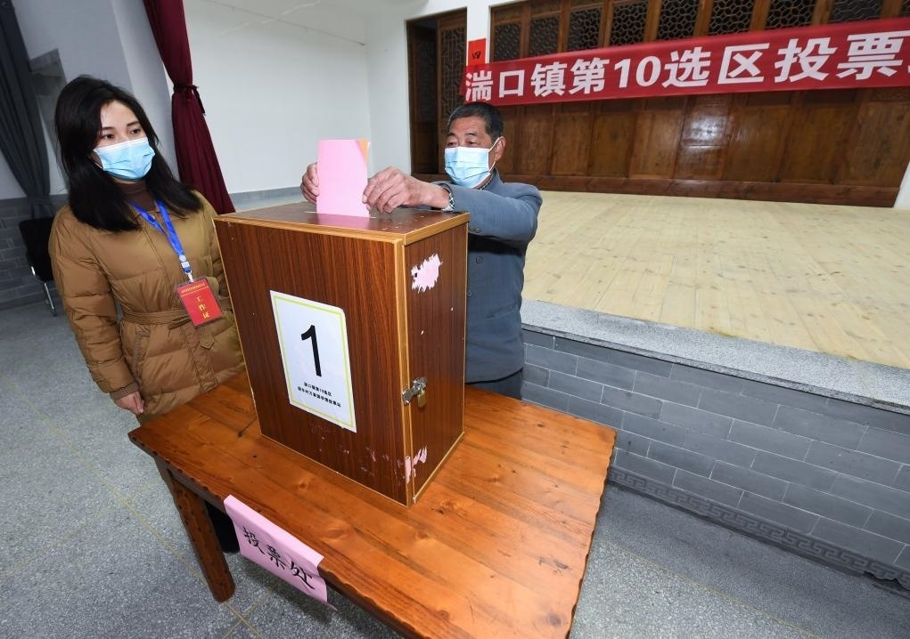 2021年12月14日，在浙江省杭州市臨安區(qū)湍口鎮(zhèn)迎豐村的基層投票點，村民在參加投票，村級監(jiān)察聯(lián)絡員監(jiān)票。新華社記者 徐昱 攝